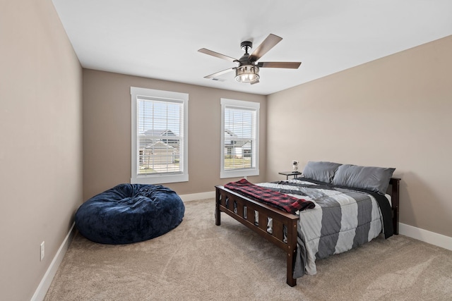 carpeted bedroom with visible vents, baseboards, and ceiling fan