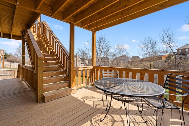 wooden deck featuring outdoor dining space and stairs