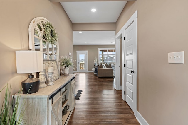 hallway with dark wood finished floors, recessed lighting, and baseboards