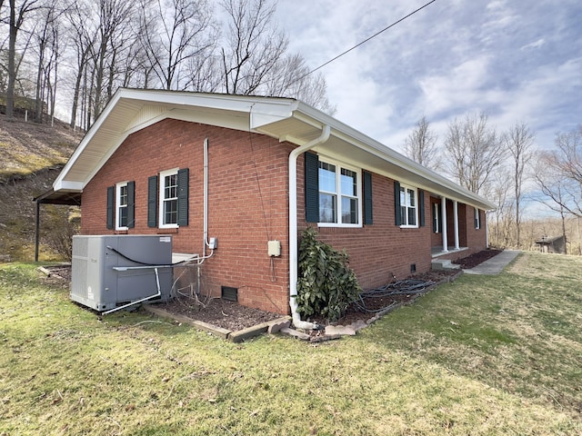 view of side of property with crawl space, a lawn, and brick siding