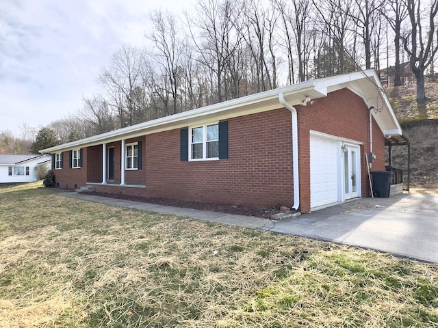 ranch-style house featuring aphalt driveway, a garage, brick siding, and a front yard