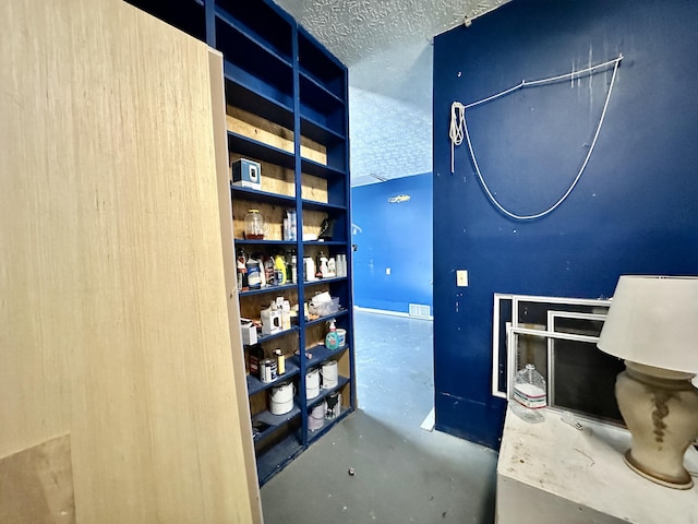 interior space featuring visible vents, a textured ceiling, and finished concrete flooring