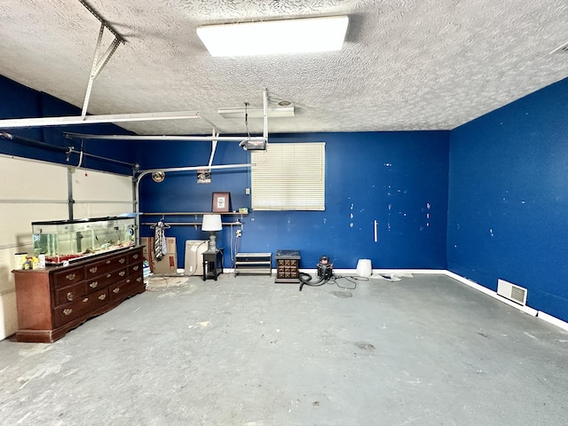 garage featuring a garage door opener, baseboards, and visible vents