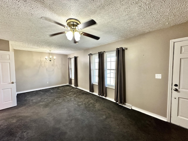 unfurnished room with a textured ceiling, ceiling fan with notable chandelier, dark colored carpet, and baseboards