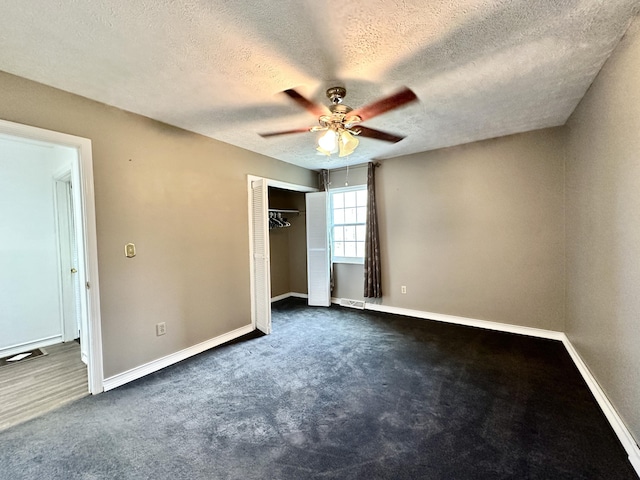 unfurnished bedroom with a closet, baseboards, and dark carpet