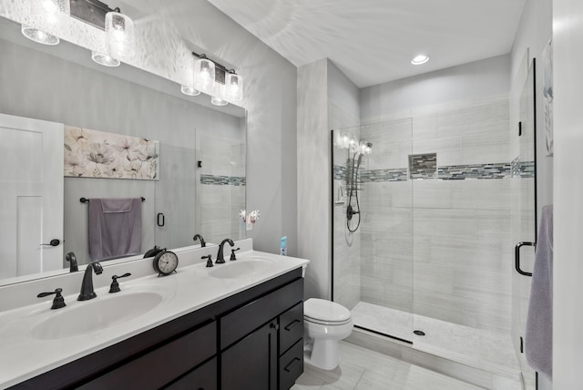 bathroom with a sink, toilet, a stall shower, and double vanity