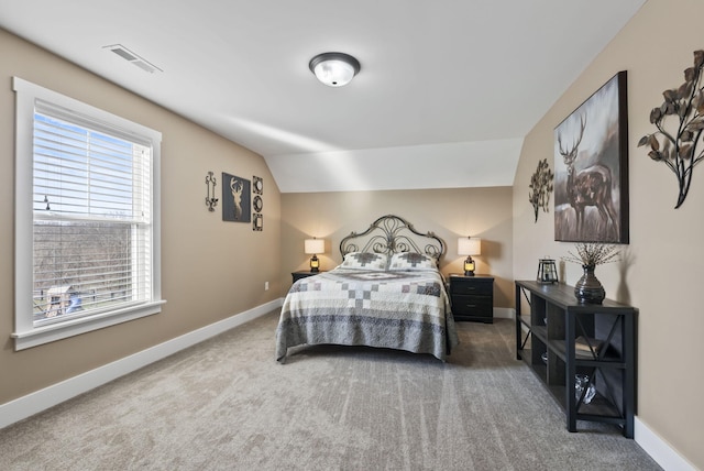 bedroom featuring visible vents, baseboards, lofted ceiling, and carpet flooring