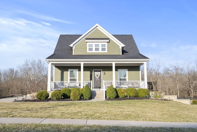 bungalow featuring roof with shingles, covered porch, and a front lawn