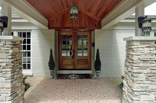 view of exterior entry with french doors and brick siding