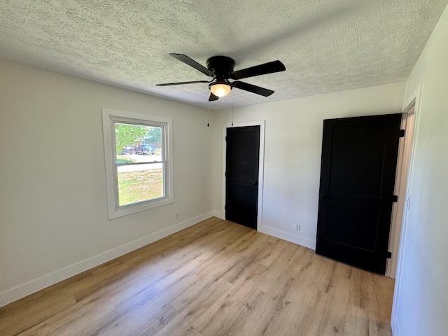 236 Walnut Ave, Somerset, KY 42503 - unfurnished bedroom with light wood-type flooring, baseboards, a textured ceiling, and ceiling fan