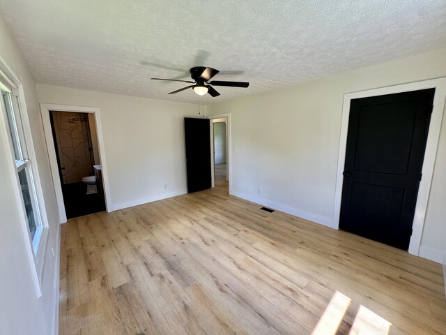 236 Walnut Ave, Somerset, KY 42503 - unfurnished bedroom with light wood finished floors, a textured ceiling, baseboards, ceiling fan, and connected bathroom