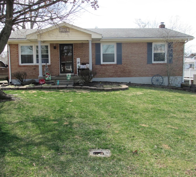 single story home with brick siding, a chimney, and a front lawn