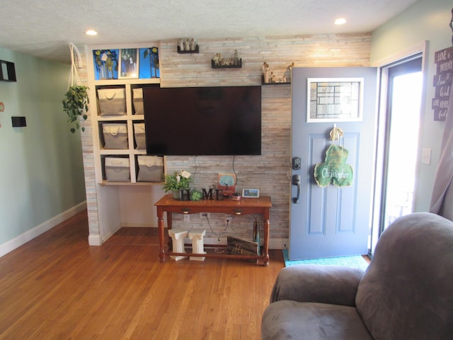 living area with recessed lighting, baseboards, and wood finished floors