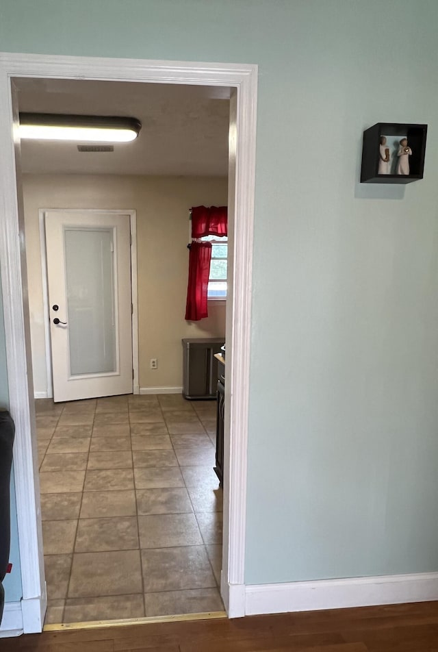 hallway with visible vents and baseboards