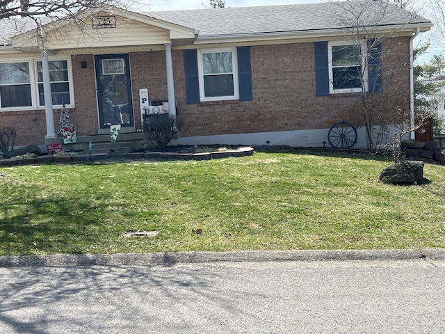 view of front of home with brick siding, roof with shingles, and a front lawn