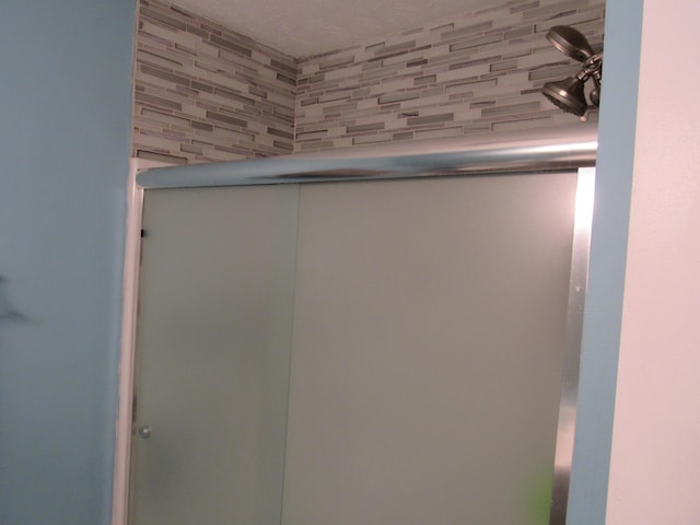 interior details featuring a shower with shower door