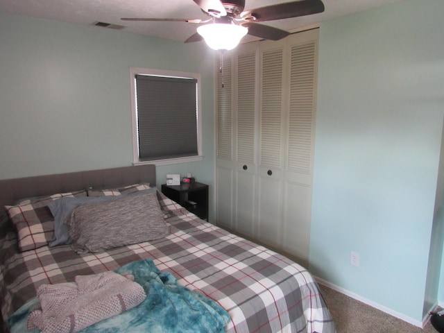 bedroom with visible vents, ceiling fan, baseboards, carpet, and a closet