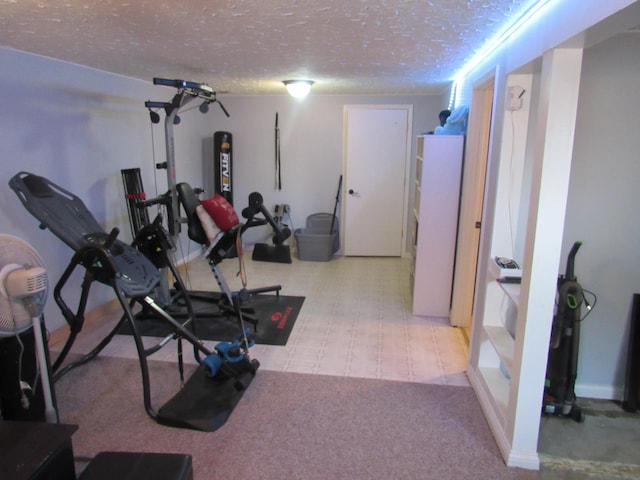 exercise room featuring light carpet and a textured ceiling