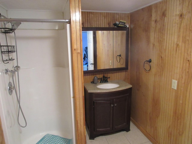 full bath with wooden walls, vanity, a shower stall, and tile patterned flooring