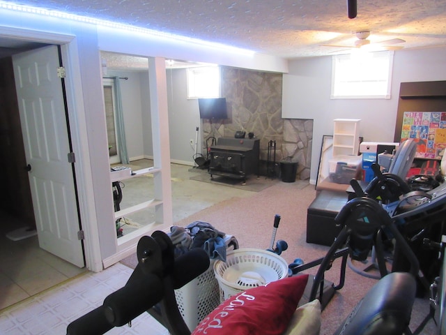 below grade area featuring a textured ceiling and a wood stove