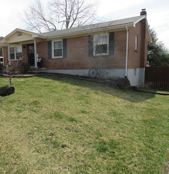 single story home with a front lawn, brick siding, a chimney, and fence