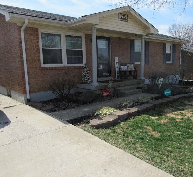 view of front facade with brick siding and a porch