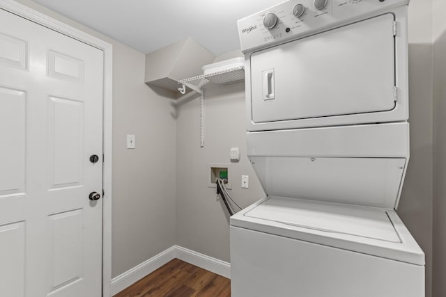 washroom featuring baseboards, stacked washer and dryer, dark wood-style flooring, and laundry area