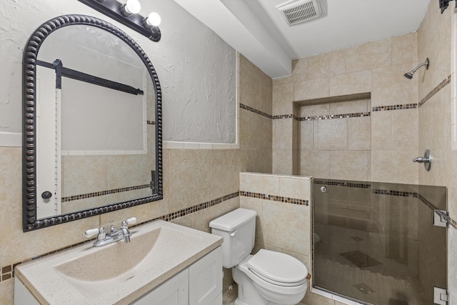 full bathroom featuring visible vents, toilet, tile walls, a shower stall, and vanity