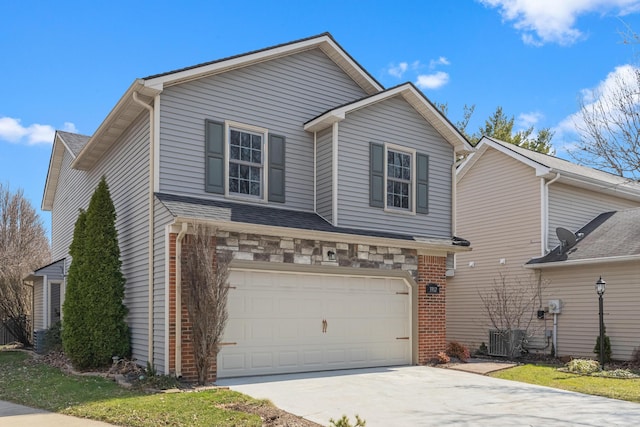 traditional-style house featuring brick siding, central AC unit, an attached garage, and concrete driveway