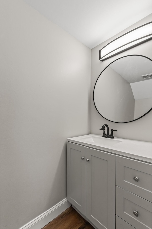 bathroom with visible vents, baseboards, wood finished floors, and vanity