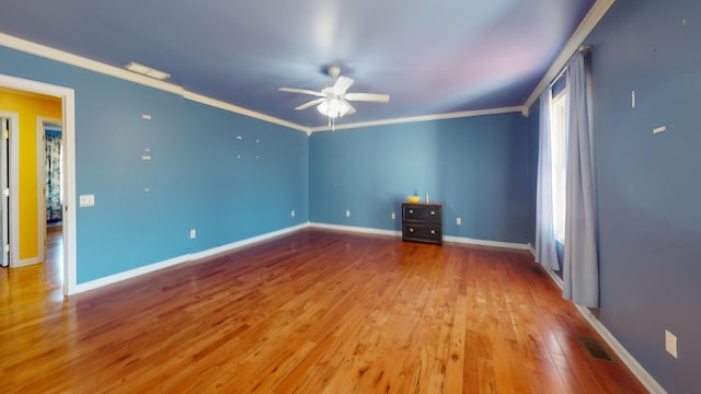 unfurnished room featuring crown molding, wood finished floors, and visible vents