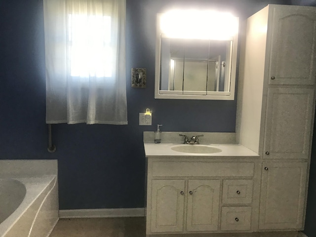 bathroom featuring a bathing tub, vanity, and baseboards