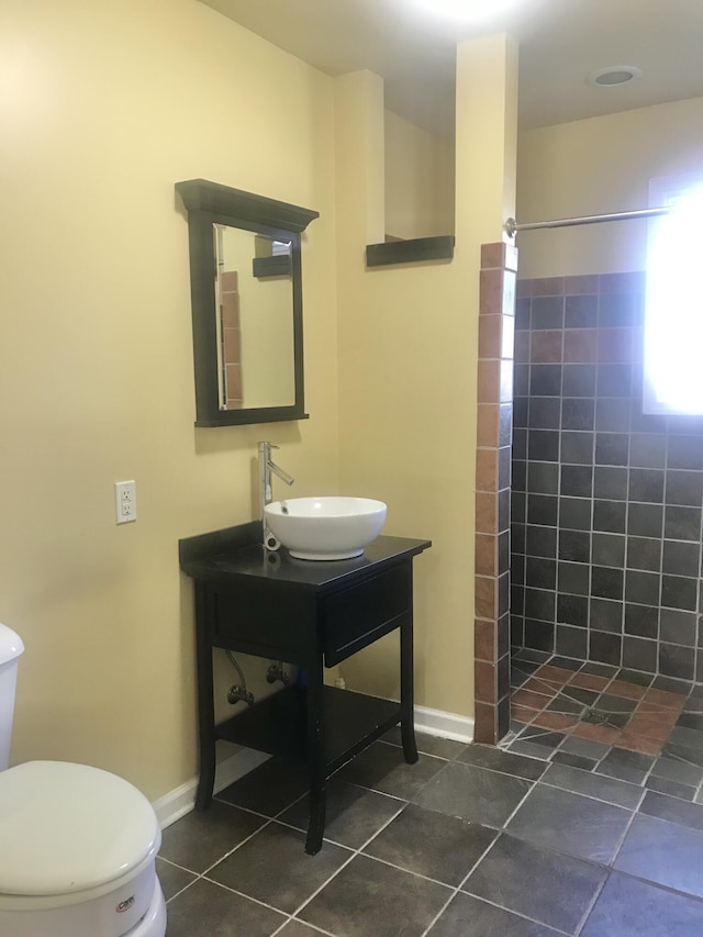 full bathroom with vanity, toilet, tile patterned flooring, and a tile shower