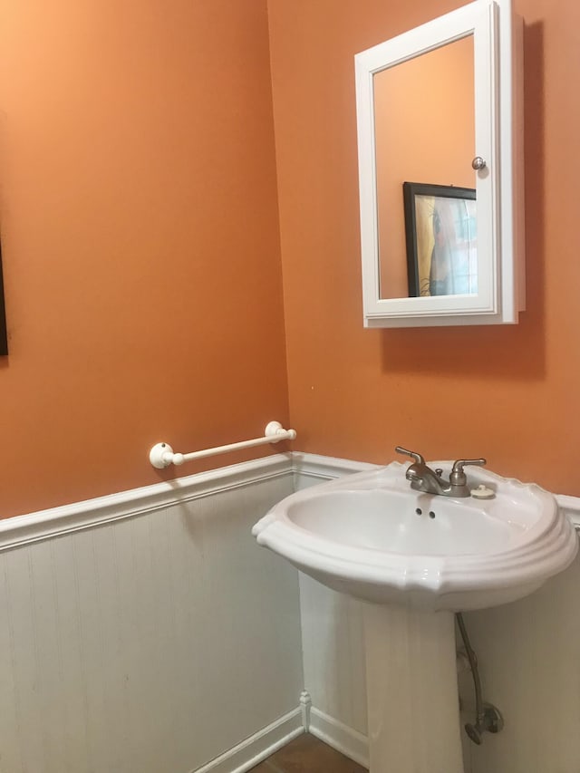 bathroom with a wainscoted wall and a sink