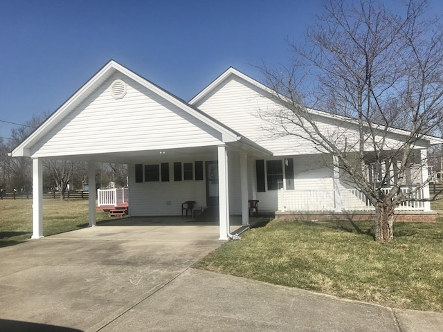 view of front of house with a carport, concrete driveway, and a front yard