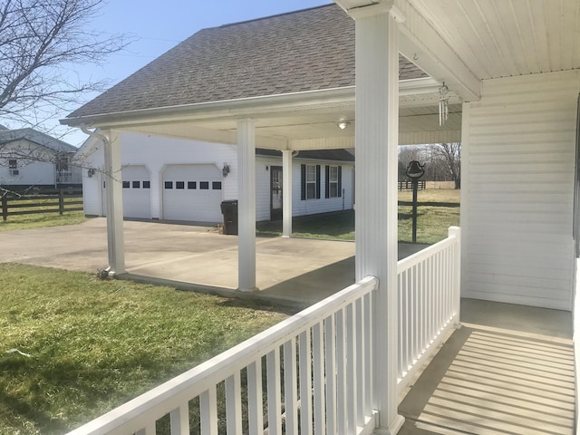 view of patio / terrace featuring concrete driveway, an attached garage, and fence