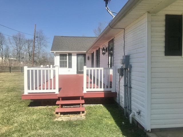 wooden terrace featuring a yard and fence