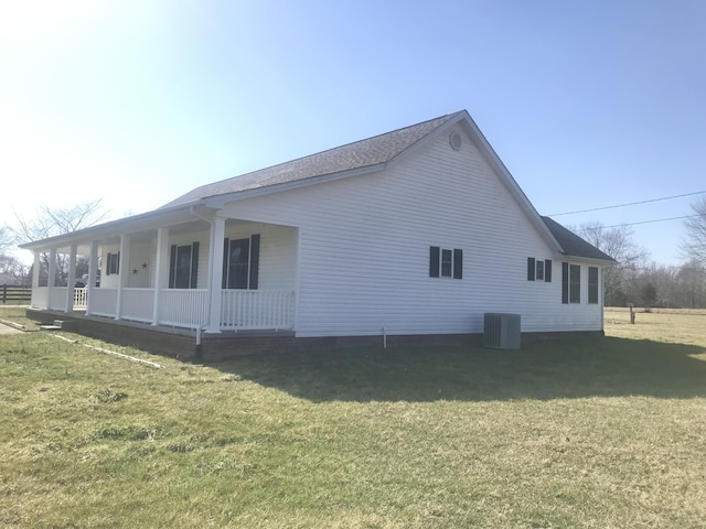 view of home's exterior with central air condition unit, a porch, and a yard