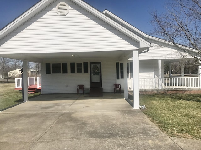 view of front of house with a carport, covered porch, concrete driveway, and a front lawn