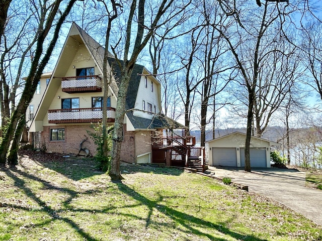 3101 Simpson Dr, Somerset, KY 42503 - view of side of home featuring a balcony, an outdoor structure, a garage, a lawn, and brick siding