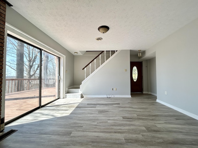 3101 Simpson Dr, Somerset, KY 42503 - unfurnished living room featuring stairway, a textured ceiling, baseboards, and wood finished floors
