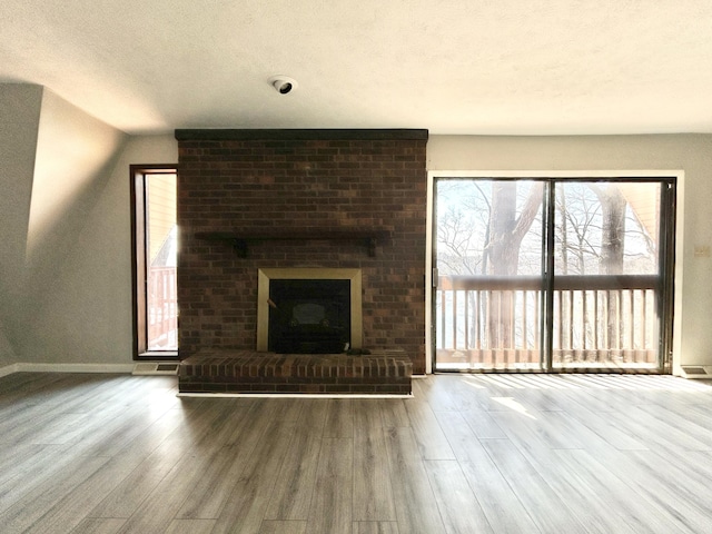 3101 Simpson Dr, Somerset, KY 42503 - unfurnished living room featuring a textured ceiling, wood finished floors, a fireplace, baseboards, and vaulted ceiling