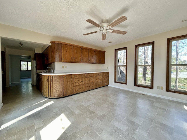 3101 Simpson Dr, Somerset, KY 42503 - kitchen featuring brown cabinetry, visible vents, a healthy amount of sunlight, and light countertops