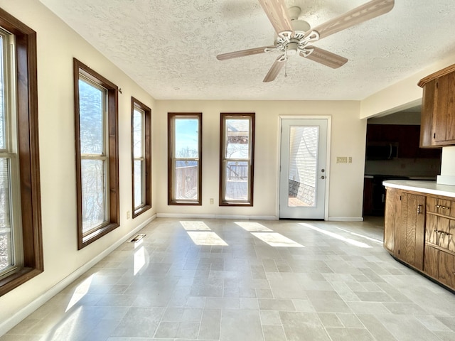 3101 Simpson Dr, Somerset, KY 42503 - kitchen with stainless steel microwave, brown cabinets, light countertops, and baseboards