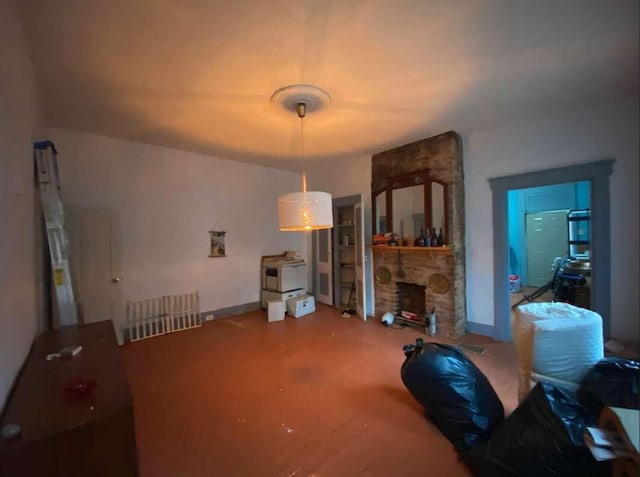 living area featuring a stone fireplace and baseboards