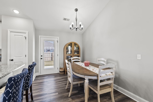 dining room featuring dark wood finished floors, an inviting chandelier, visible vents, and lofted ceiling