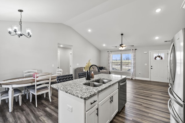 kitchen with a sink, decorative light fixtures, vaulted ceiling, appliances with stainless steel finishes, and dark wood-style flooring