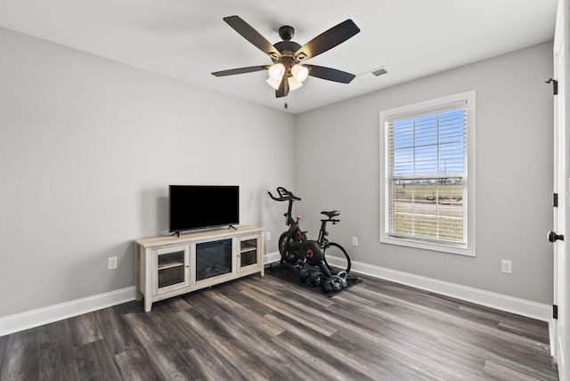 workout area featuring dark wood finished floors, baseboards, visible vents, and a ceiling fan