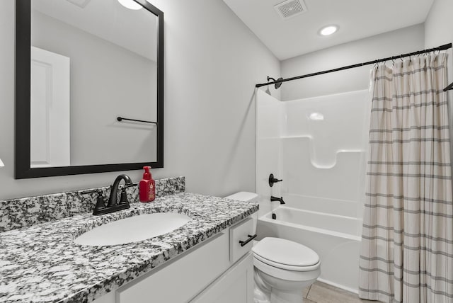 bathroom featuring visible vents, vanity, toilet, and shower / tub combo with curtain