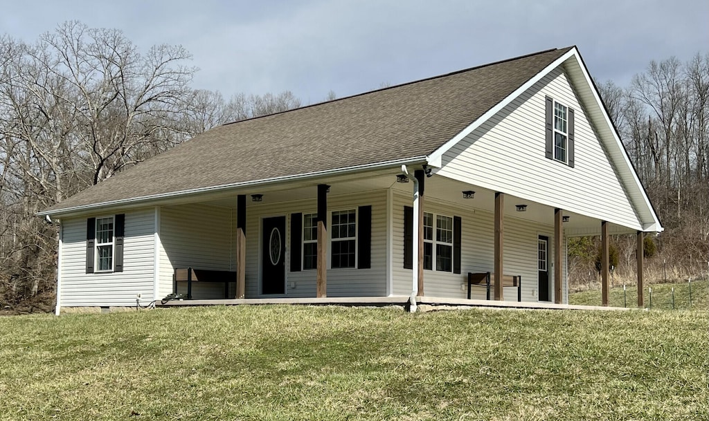 farmhouse inspired home featuring roof with shingles and a front lawn